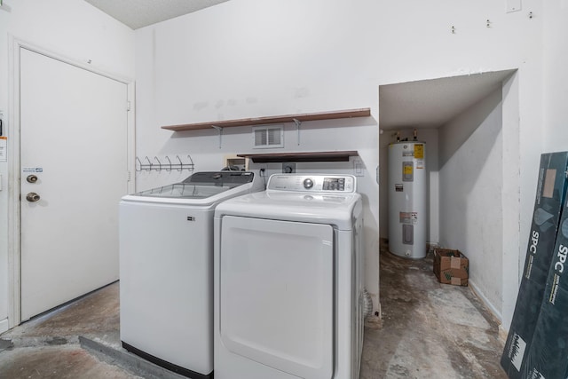 laundry room with water heater, a textured ceiling, and washer and dryer