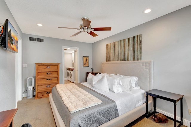 carpeted bedroom with ceiling fan, washing machine and dryer, and ensuite bath