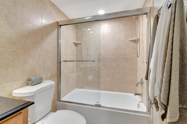 full bathroom with shower / bath combination with glass door, vanity, tile walls, and toilet