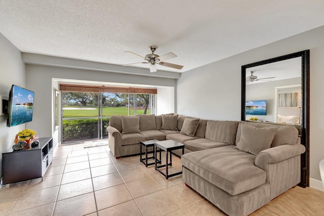 living room featuring ceiling fan, light tile patterned floors, and a textured ceiling