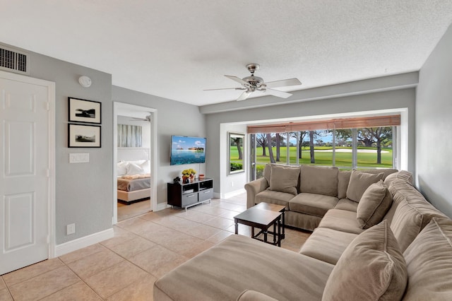 tiled living room with plenty of natural light, ceiling fan, and a textured ceiling