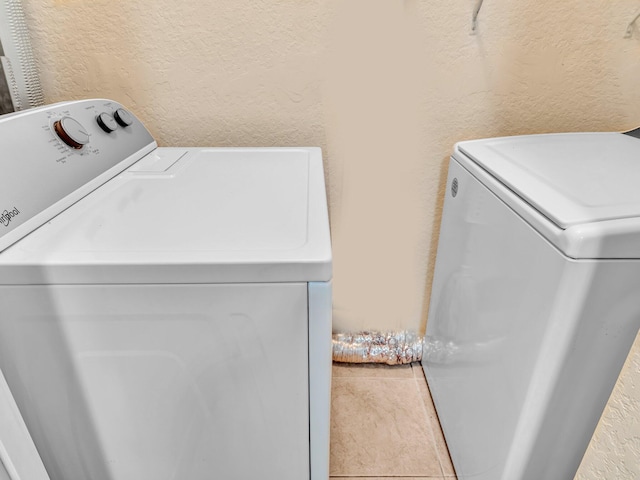 laundry area with washing machine and dryer and tile patterned floors