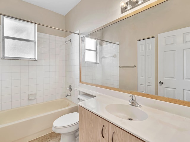 full bathroom featuring toilet, tiled shower / bath combo, vanity, and tile patterned flooring