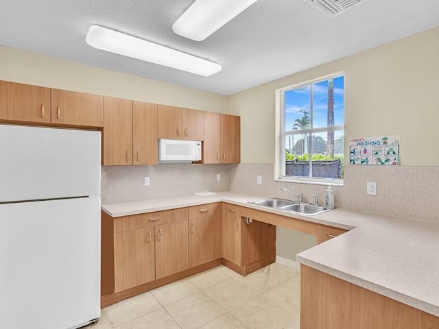 kitchen featuring a textured ceiling, tasteful backsplash, sink, light tile patterned flooring, and white appliances