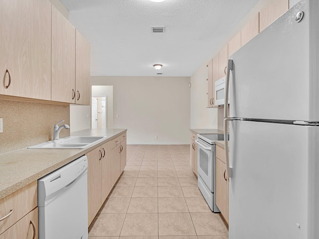 kitchen featuring light tile patterned floors, white appliances, light brown cabinetry, and sink