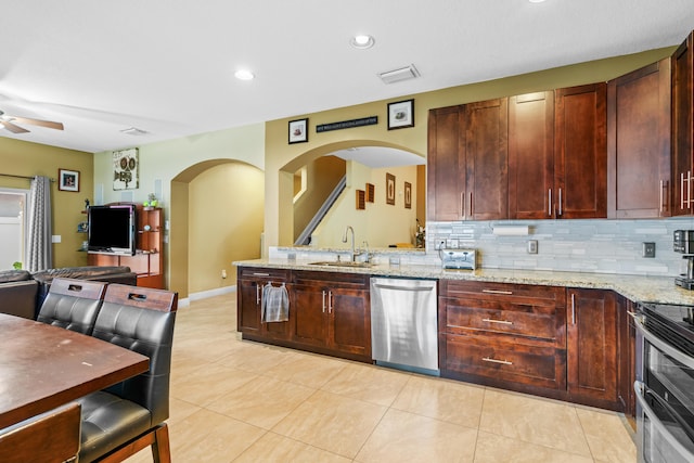 kitchen with light stone counters, light tile patterned flooring, stainless steel appliances, backsplash, and sink