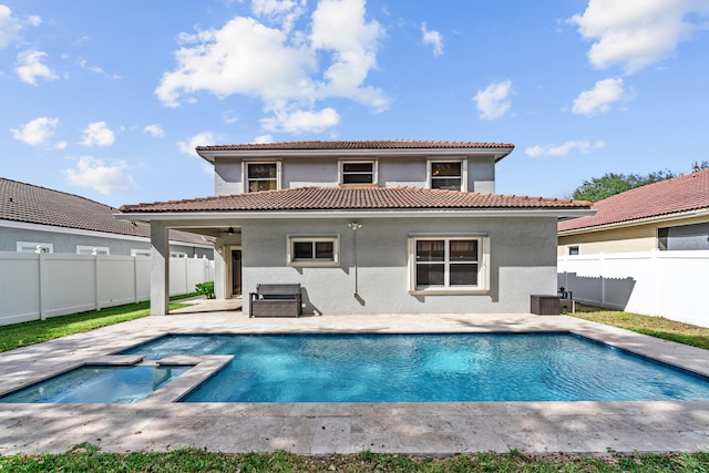 rear view of house with a fenced in pool and a patio