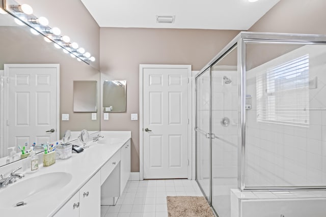 bathroom with tile patterned flooring, vanity, and a shower with shower door