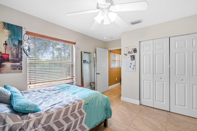 bedroom with a closet, multiple windows, light tile patterned flooring, and ceiling fan