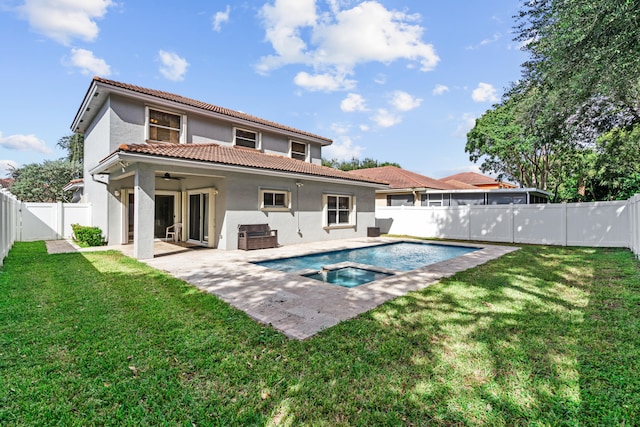 back of house featuring ceiling fan, a patio, a yard, and a fenced in pool