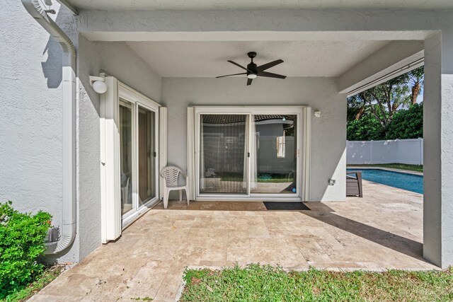 view of patio / terrace featuring ceiling fan and a fenced in pool