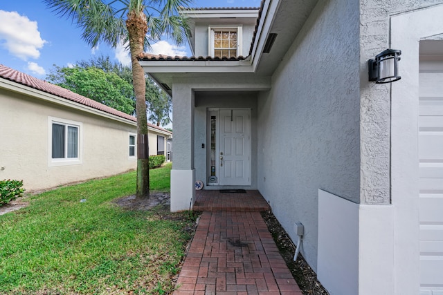 entrance to property with a lawn