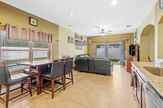 tiled dining room with ceiling fan and sink