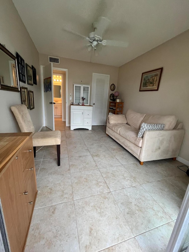 living room with ceiling fan and tile patterned floors