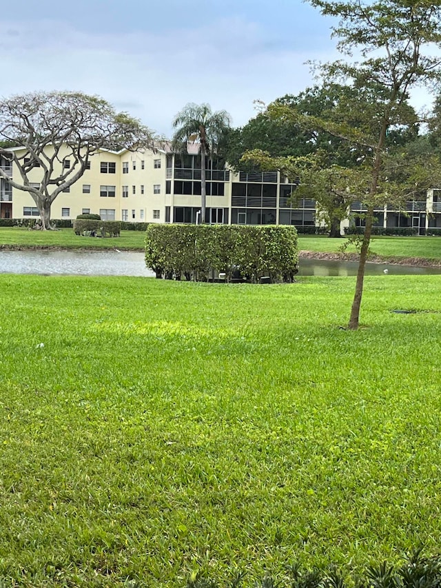 view of property's community featuring a water view and a lawn