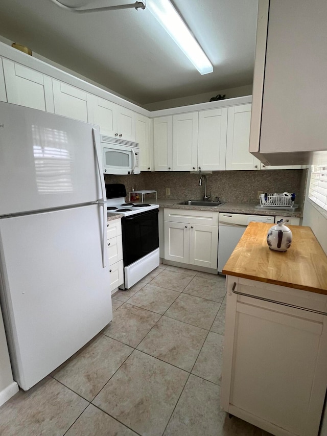 kitchen featuring light tile patterned flooring, wooden counters, sink, white cabinets, and white appliances