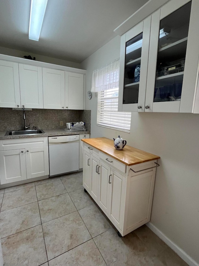 kitchen featuring tasteful backsplash, sink, white dishwasher, and white cabinets