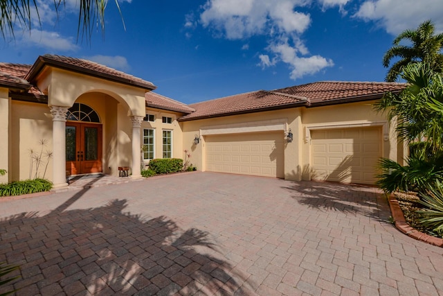 mediterranean / spanish-style home featuring french doors and a garage