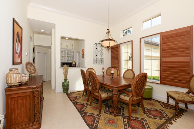 dining room with light tile patterned floors and crown molding