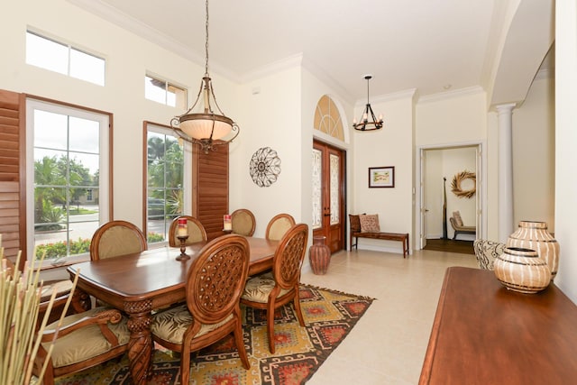 dining space with light tile patterned floors, a high ceiling, french doors, ornamental molding, and ornate columns