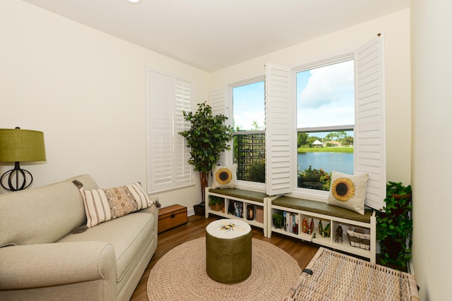 living area with hardwood / wood-style flooring and a water view