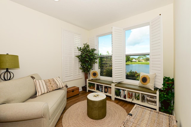 sitting room featuring a water view and wood-type flooring