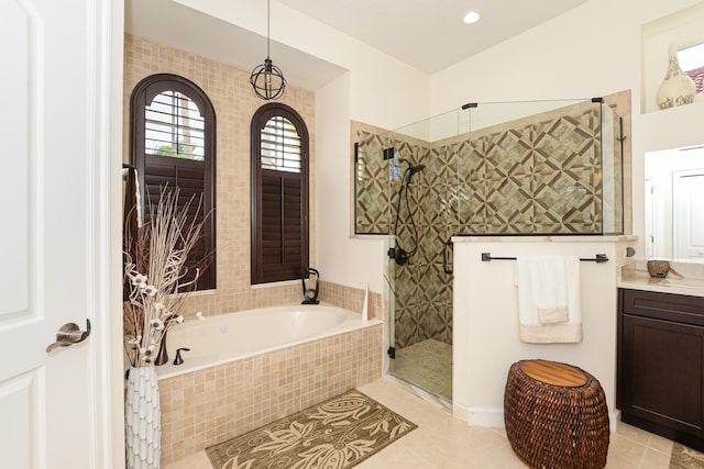 bathroom with tile patterned flooring, shower with separate bathtub, and vanity