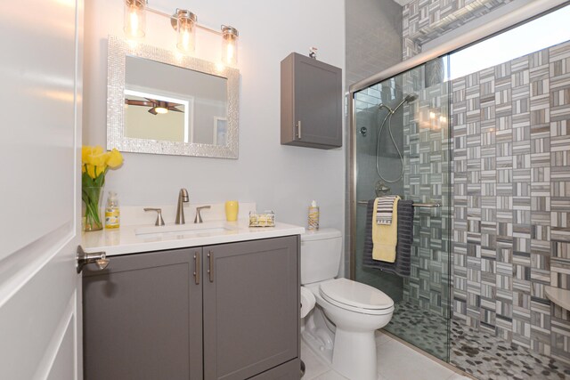 bathroom with tile patterned flooring, vanity, toilet, and walk in shower