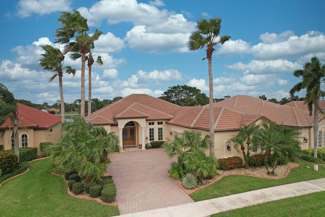 mediterranean / spanish-style home with a front yard