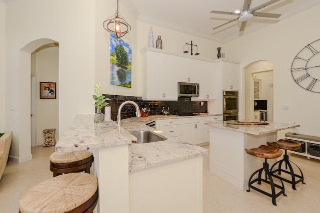 kitchen featuring kitchen peninsula, stainless steel appliances, sink, light tile patterned floors, and a breakfast bar area