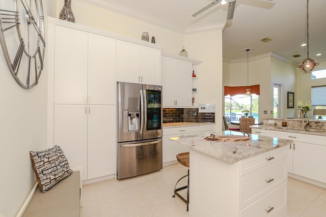 kitchen with white cabinetry, sink, a center island, and stainless steel refrigerator with ice dispenser