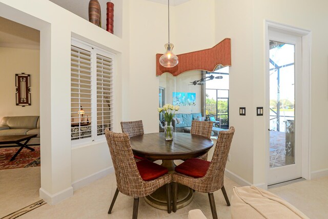 tiled living room with a towering ceiling, plenty of natural light, crown molding, and ceiling fan