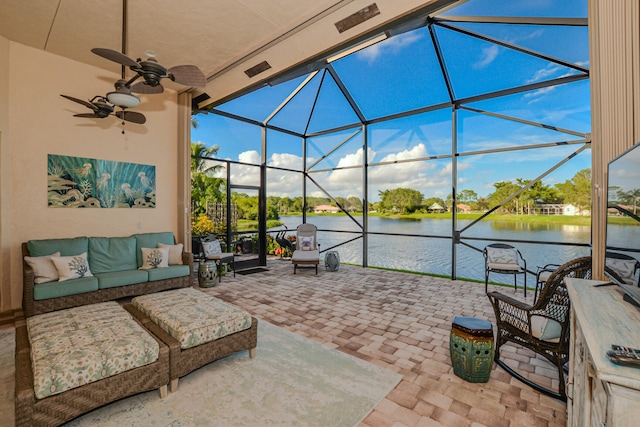 view of patio / terrace with an outdoor living space, ceiling fan, a water view, and glass enclosure