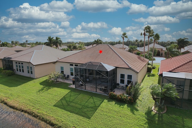 back of house featuring a yard, a patio area, and a lanai