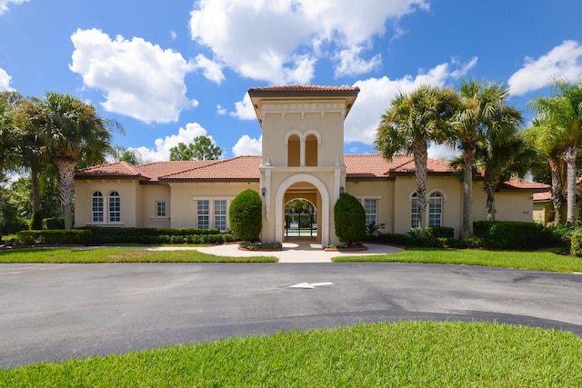 mediterranean / spanish-style house with a front yard