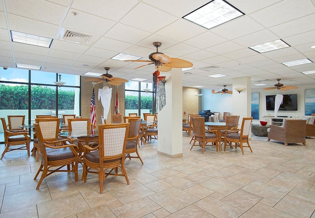 dining room featuring a wall of windows and a drop ceiling