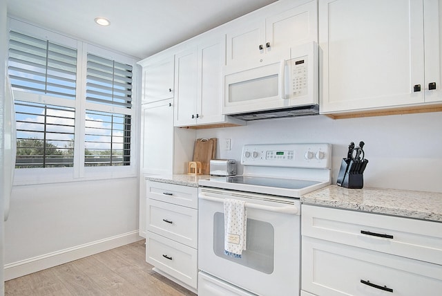 kitchen with white cabinetry, light hardwood / wood-style floors, white appliances, and light stone countertops