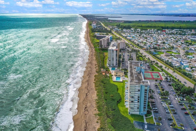 birds eye view of property with a water view and a beach view