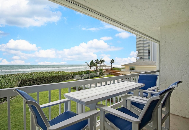 balcony featuring a water view and a beach view