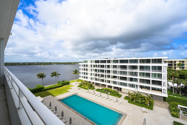 view of swimming pool featuring a water view and a patio area