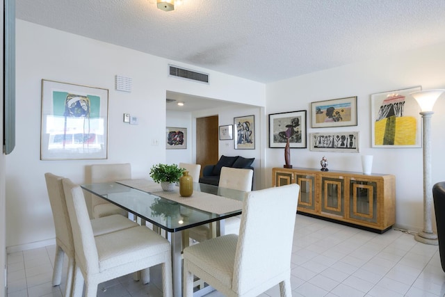 dining room featuring a textured ceiling and light tile patterned floors