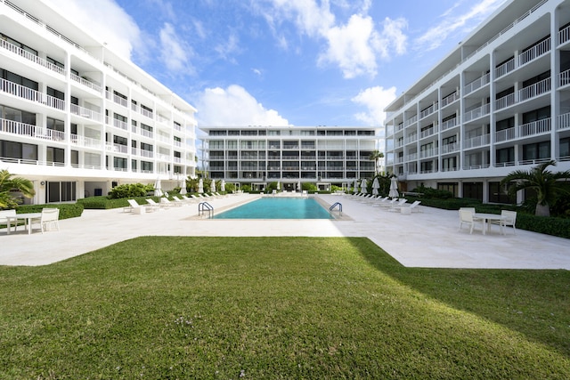 view of pool featuring a patio area and a yard