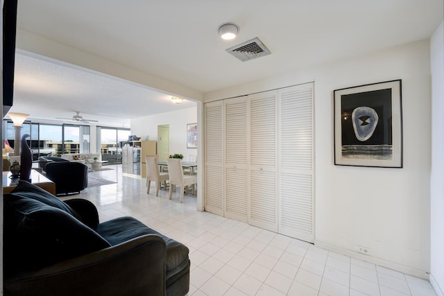 living room with floor to ceiling windows, light tile patterned floors, and ceiling fan