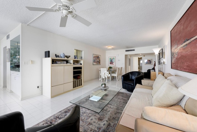 tiled living room featuring a textured ceiling and ceiling fan