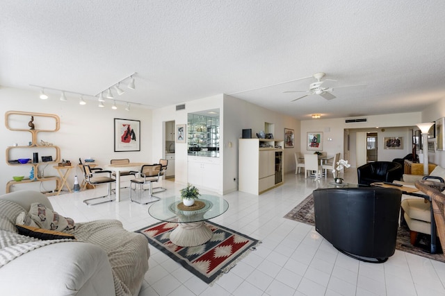 living room with a textured ceiling and ceiling fan