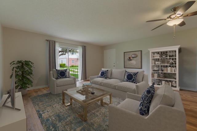 living room with ceiling fan, baseboards, and wood finished floors