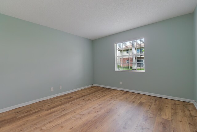 unfurnished dining area featuring an inviting chandelier, wood-type flooring, visible vents, and baseboards