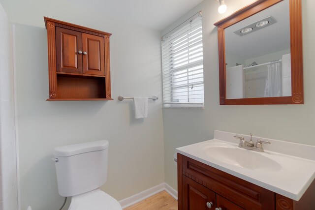 full bath with tiled shower, vanity, and toilet