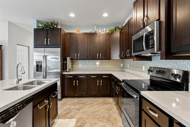 kitchen featuring decorative backsplash, sink, light stone countertops, appliances with stainless steel finishes, and dark brown cabinets