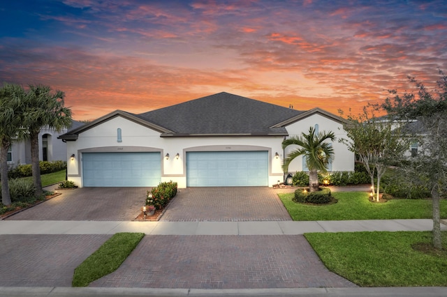 view of front facade with a yard and a garage